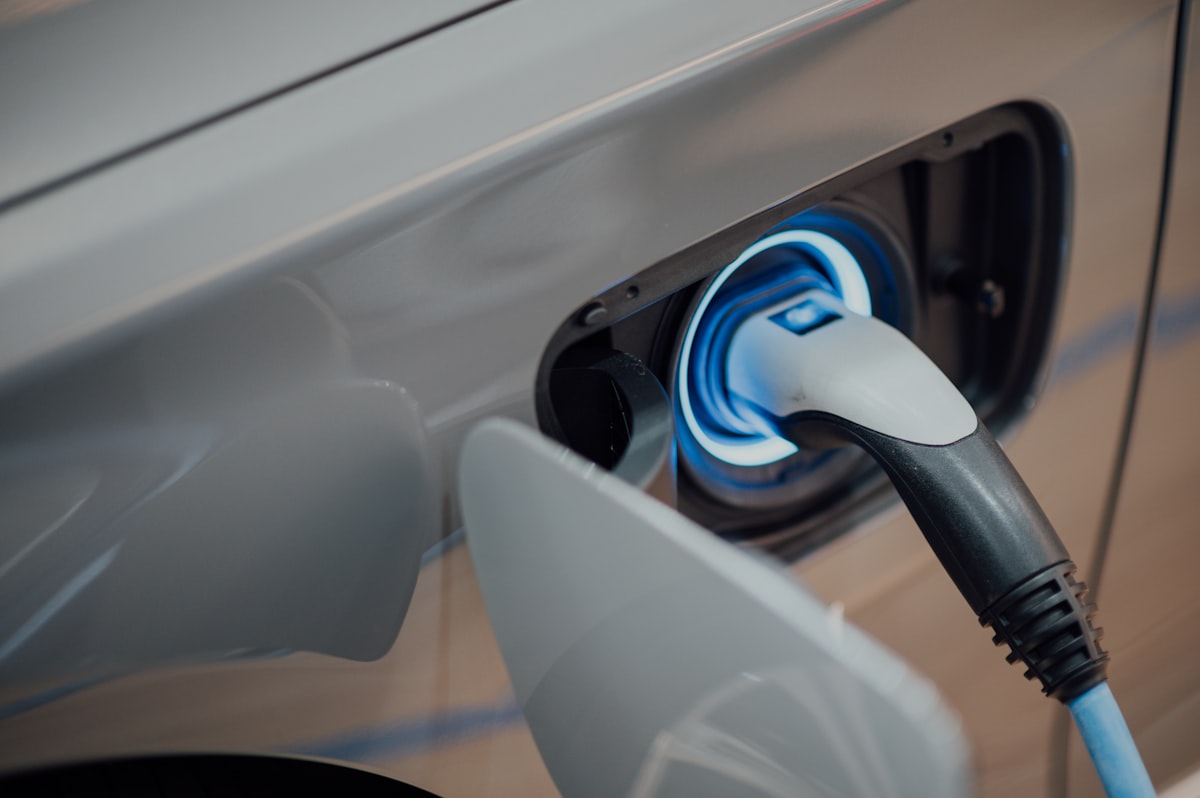 Electric car plugged into a home charger in a driveway